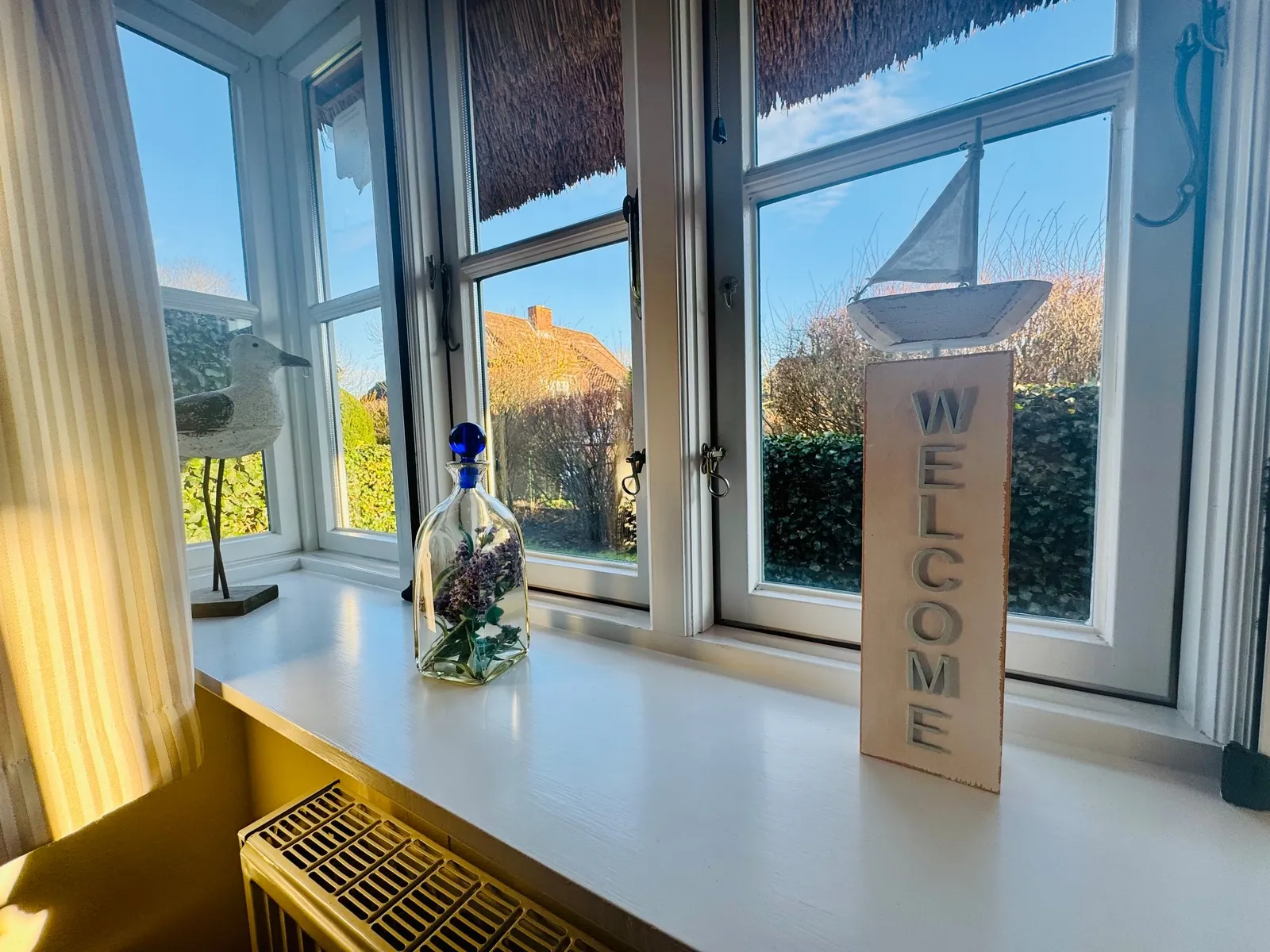 Fensterbank mit maritimer Deko und Blick ins Grüne