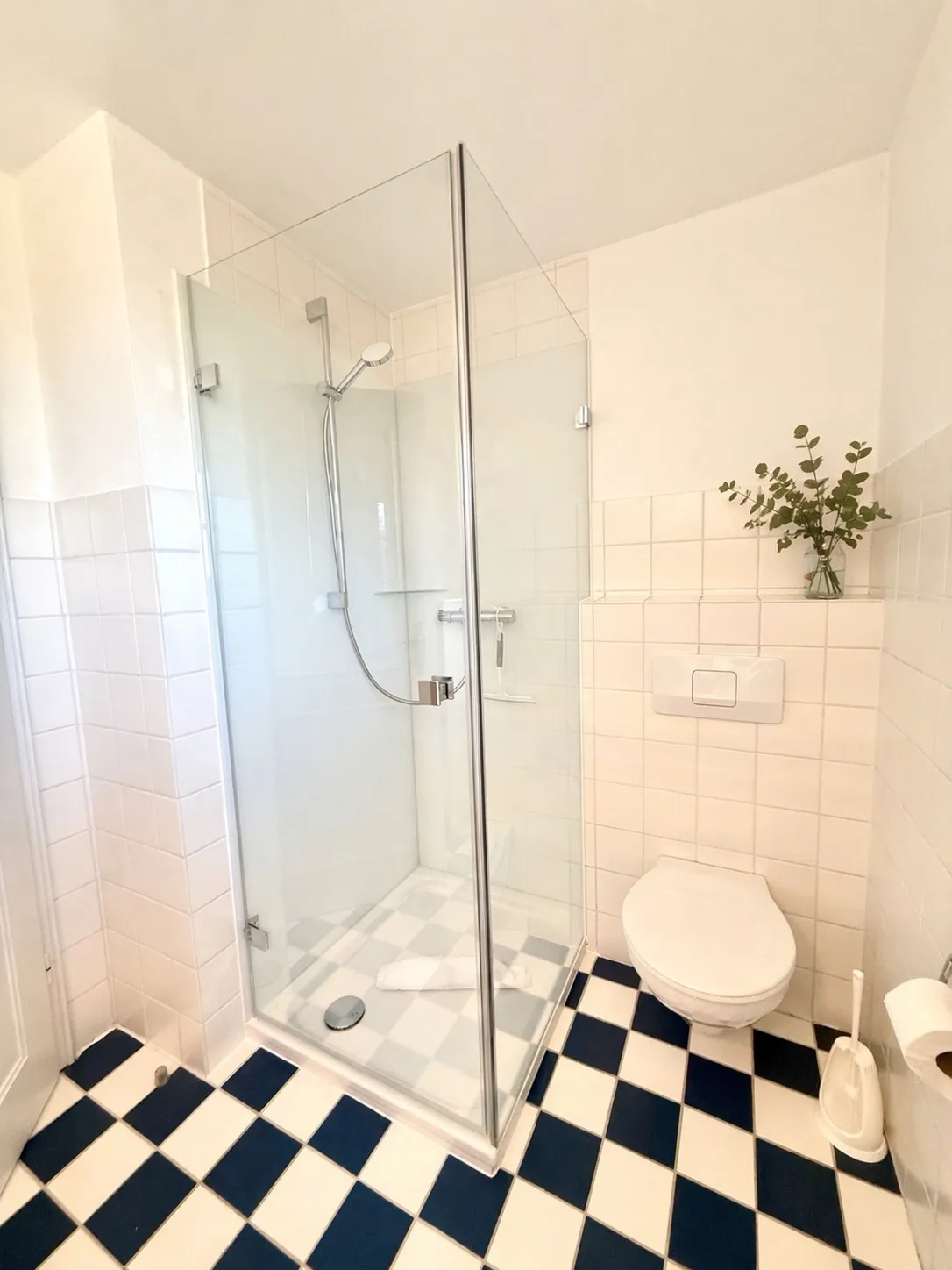 Modernisierte Glas-Eckduschkabine mit Wand-WC im Bad der Ferienwohnung