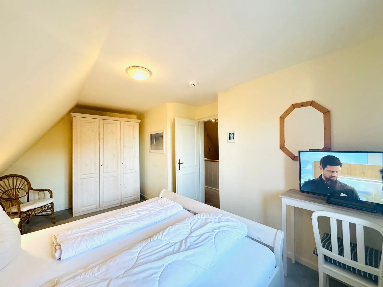Schlafzimmer im Obergeschoss mit Doppelbett, Kleiderschrank und Dachschräge