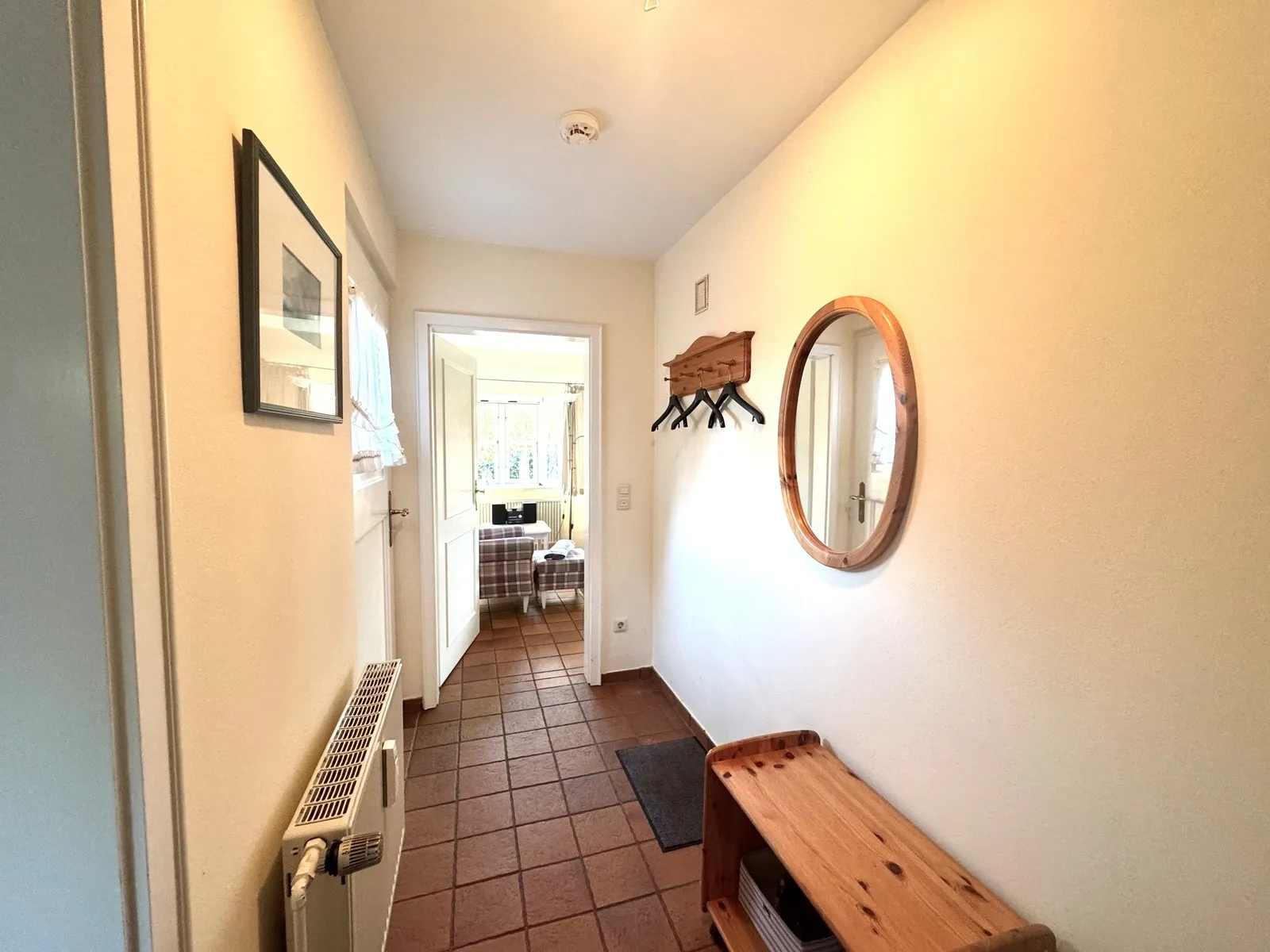 Flur mit Garderobe und Blick ins Wohnzimmer der Ferienwohnung